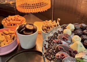 Assorted cookies and chocolates, including Oreo cookies, wafer rolls, and chocolate-covered treats, displayed on a dessert table at Pakorn.